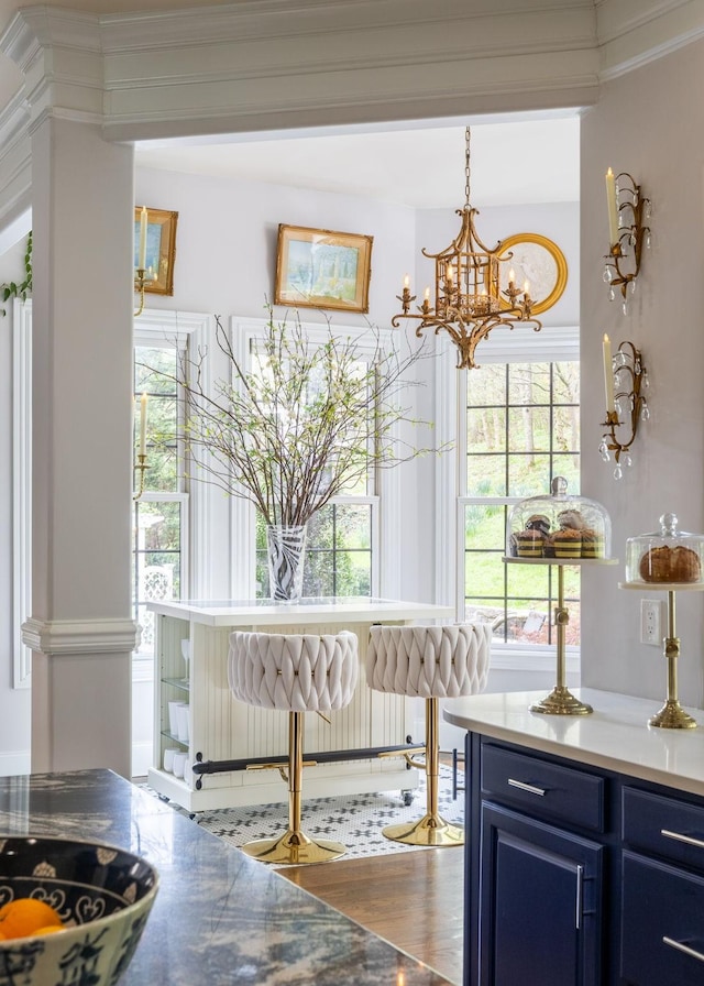 interior space with ornamental molding, wood finished floors, and a chandelier