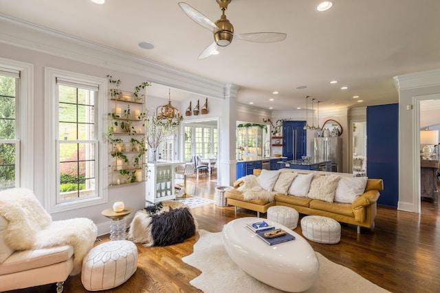 living room featuring ceiling fan, ornamental molding, wood finished floors, and plenty of natural light