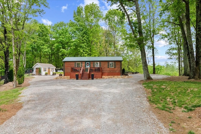 6498 Arno College Grove Rd, College Grove, TN 37046 - view of front of house with dirt driveway, a deck, an outbuilding, and metal roof