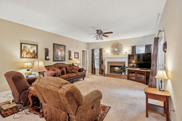 living room with carpet floors, a ceiling fan, a textured ceiling, and a fireplace
