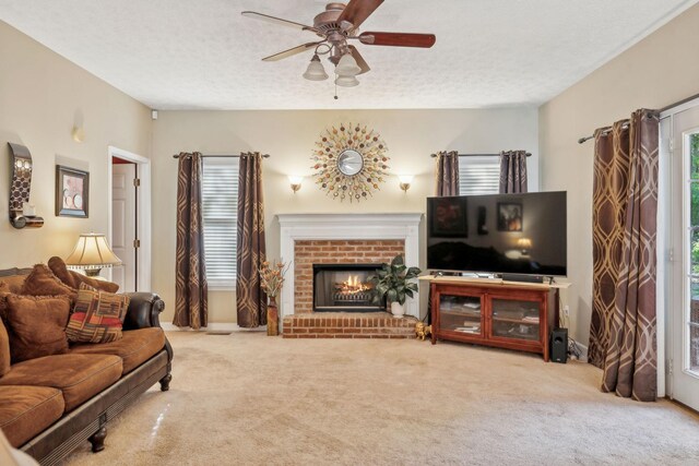 carpeted living area featuring a ceiling fan, a textured ceiling, and a fireplace