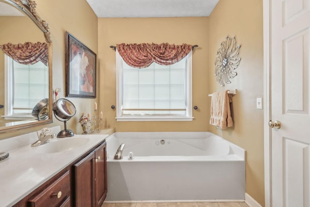 bathroom featuring a textured ceiling, a garden tub, and vanity