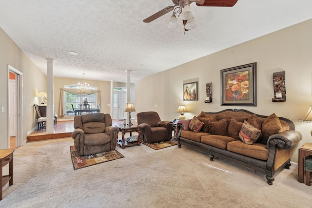 carpeted living area with ornate columns, a textured ceiling, and ceiling fan with notable chandelier