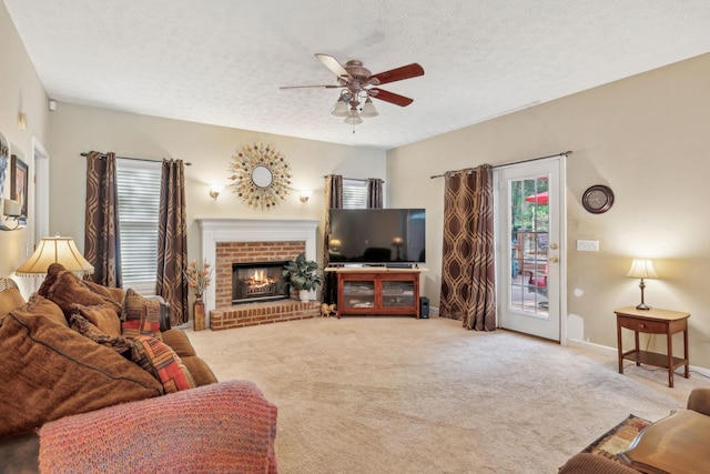 living area with a brick fireplace, a textured ceiling, carpet, and ceiling fan