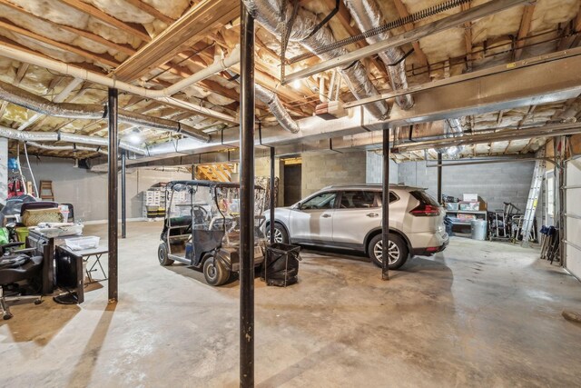 garage with a garage door opener and concrete block wall