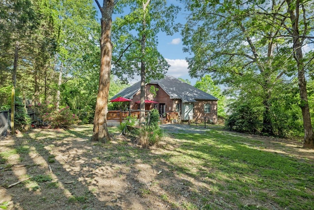 rear view of property featuring a yard and a deck