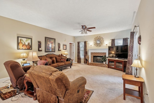 living room featuring carpet floors, a ceiling fan, a textured ceiling, and a brick fireplace