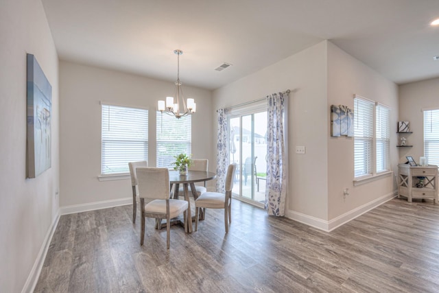 dining room featuring baseboards, plenty of natural light, wood finished floors, and visible vents