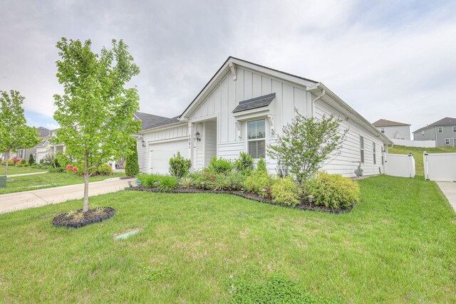 ranch-style home featuring a garage, board and batten siding, concrete driveway, and a front lawn