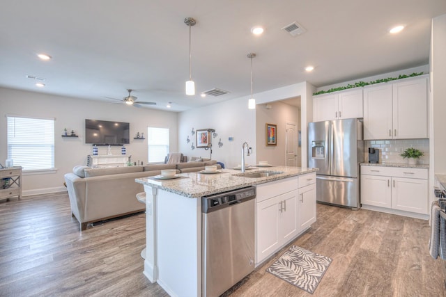 kitchen with visible vents, appliances with stainless steel finishes, a sink, light wood-style flooring, and a wealth of natural light