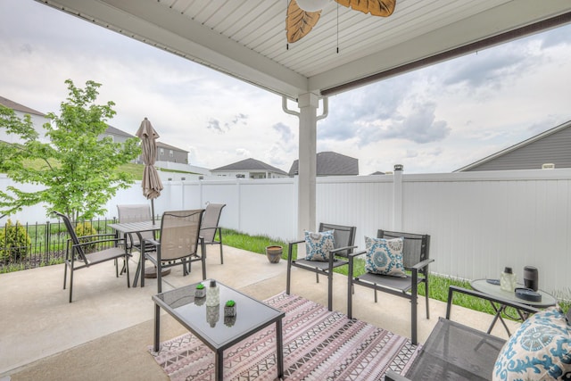 view of patio featuring a fenced backyard, a ceiling fan, and outdoor dining space