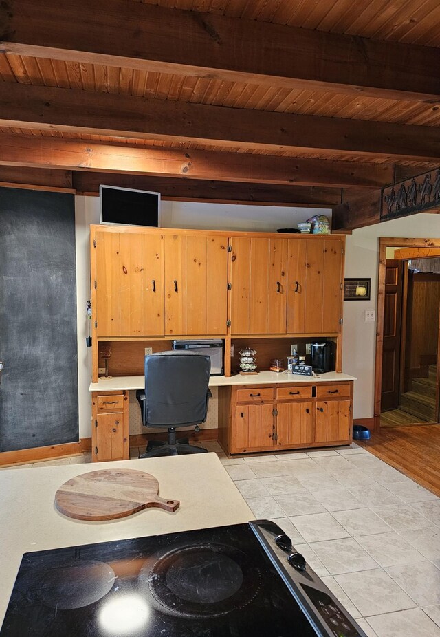 office space featuring wooden ceiling, built in desk, and beam ceiling