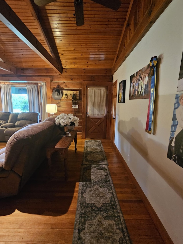 hallway with lofted ceiling with beams, wood walls, wood ceiling, and wood finished floors