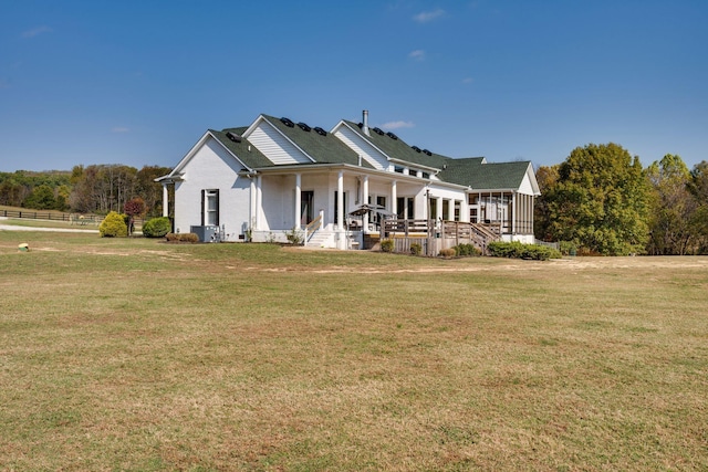 view of side of property featuring a lawn and covered porch