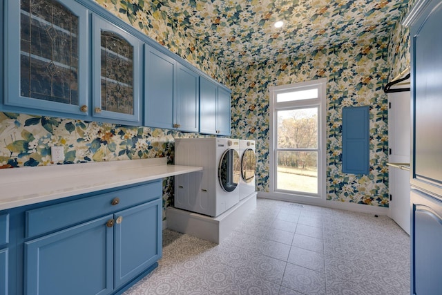 clothes washing area featuring separate washer and dryer, cabinet space, a healthy amount of sunlight, and wallpapered walls