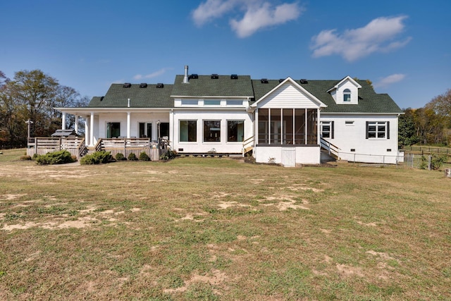 back of house featuring a sunroom, a lawn, and fence