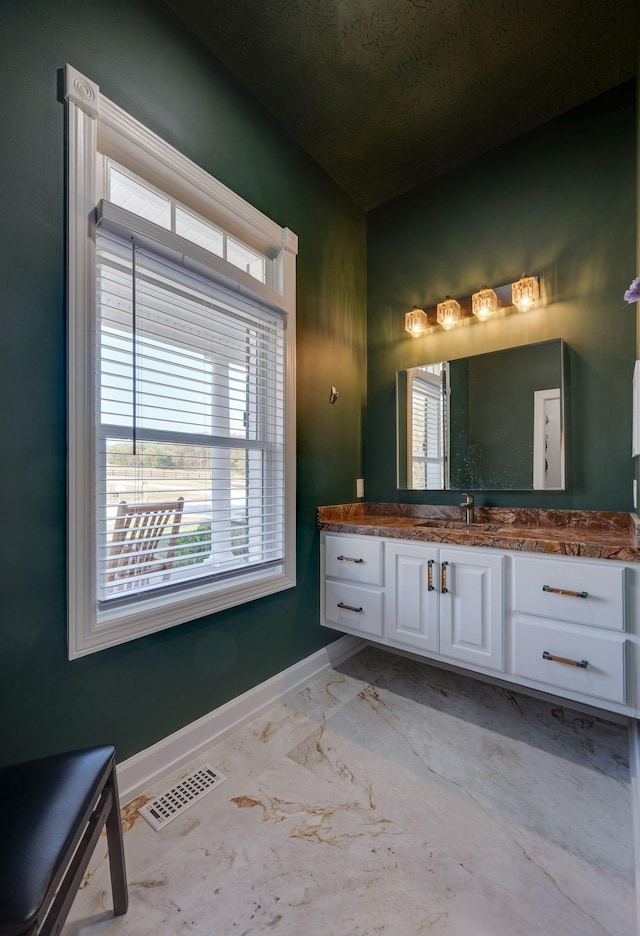 bathroom with baseboards, vanity, marble finish floor, and visible vents