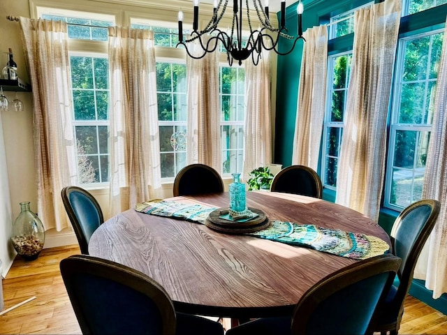 dining area featuring baseboards, a chandelier, and wood finished floors