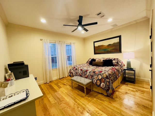 bedroom with crown molding, visible vents, baseboards, and light wood-style flooring
