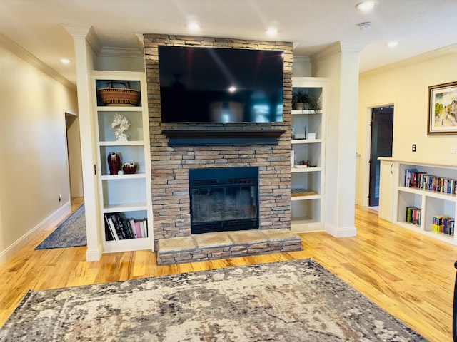 living room featuring built in shelves, crown molding, baseboards, and wood finished floors