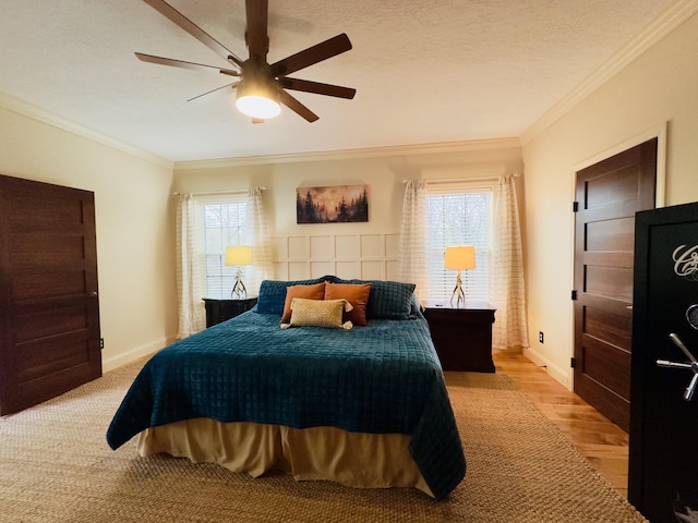 bedroom with light wood finished floors, ornamental molding, a ceiling fan, and multiple windows