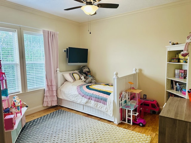 bedroom featuring baseboards, ceiling fan, light wood-style flooring, and crown molding