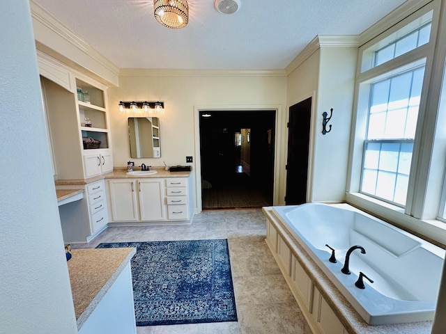 bathroom featuring a garden tub, a textured ceiling, vanity, and ornamental molding