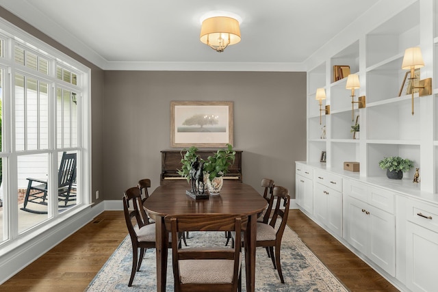 dining area with crown molding and dark wood-style flooring