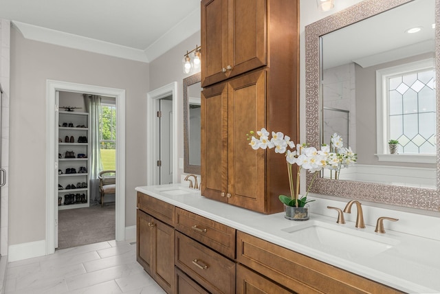 bathroom with a sink, crown molding, a shower stall, and double vanity
