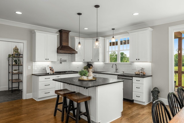 kitchen featuring a sink, backsplash, wall chimney exhaust hood, and dishwasher