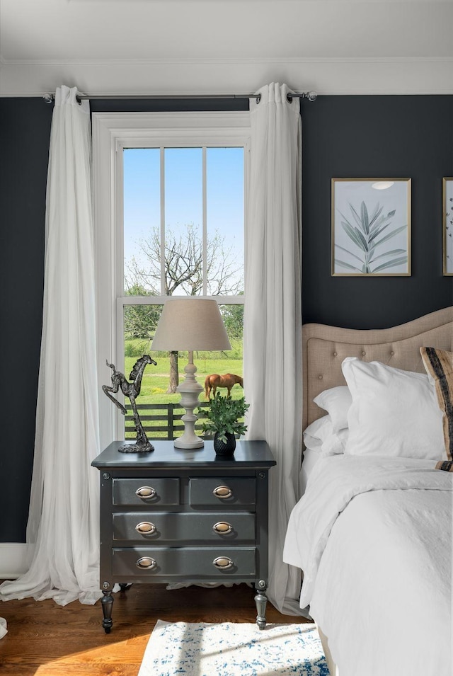 bedroom featuring crown molding and wood finished floors