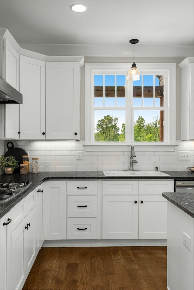 kitchen featuring decorative backsplash, decorative light fixtures, stainless steel gas cooktop, a sink, and white cabinetry