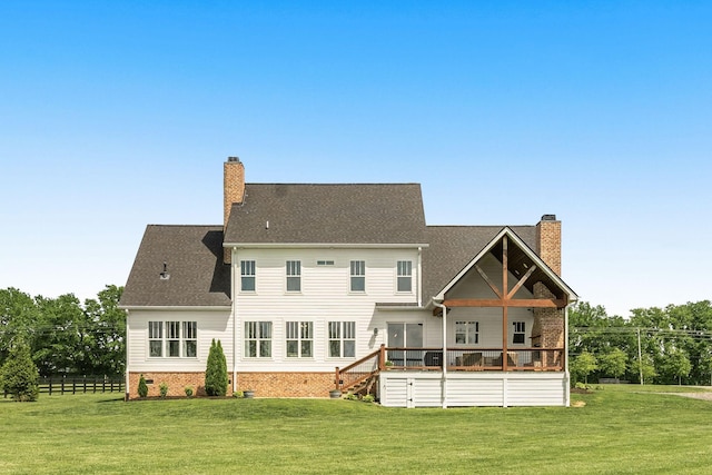 rear view of property featuring a yard and a chimney
