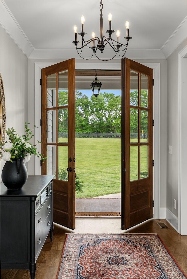 doorway with baseboards, a notable chandelier, ornamental molding, and french doors