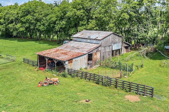 view of barn with fence and a yard