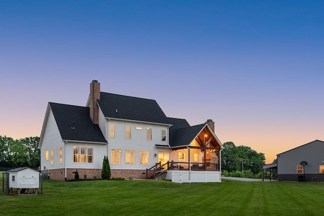 back of property with a yard, crawl space, and a chimney