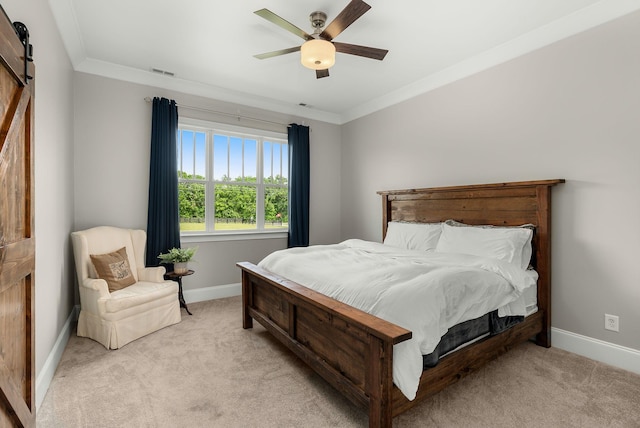 bedroom with crown molding, visible vents, baseboards, light colored carpet, and a barn door