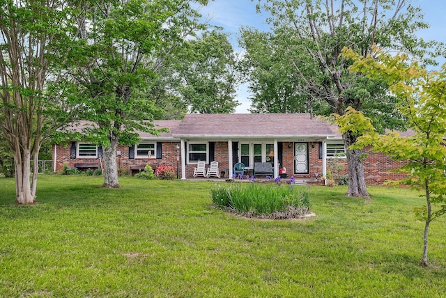 ranch-style home featuring a porch, a front lawn, and brick siding