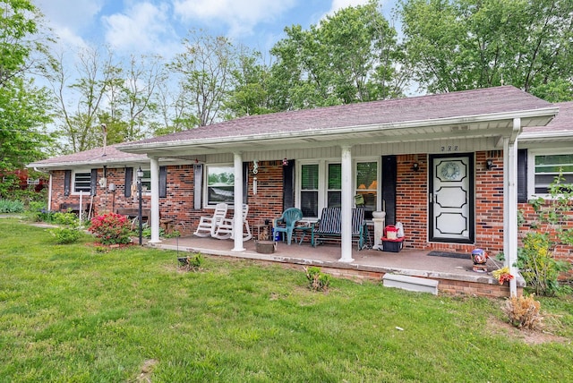 ranch-style house with covered porch, brick siding, roof with shingles, and a front lawn