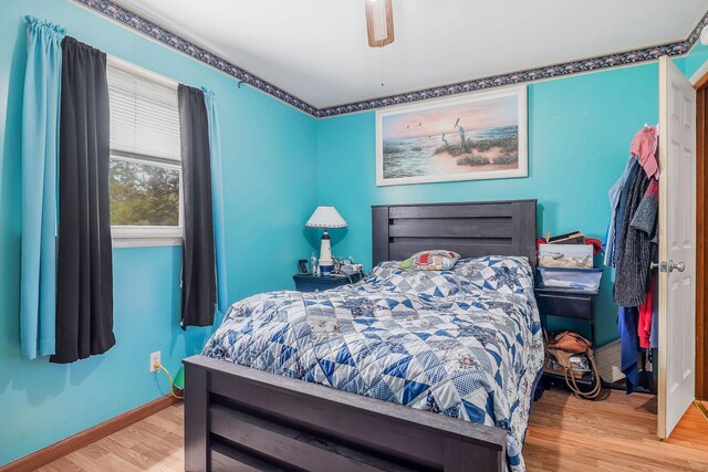 bedroom featuring a ceiling fan, baseboards, and wood finished floors