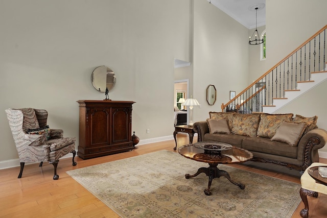 7237 River Run Dr, Chattanooga, TN 37416 - living room featuring light wood-style floors, baseboards, a high ceiling, stairway, and a chandelier