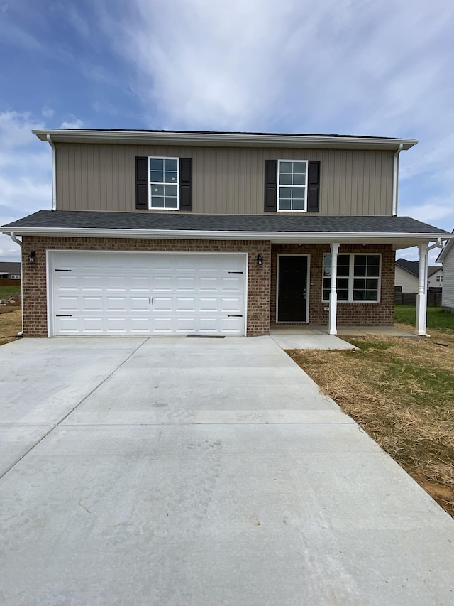 traditional-style house featuring brick siding, an attached garage, and driveway