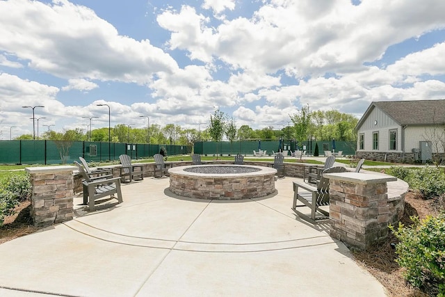 view of patio with fence and a fire pit