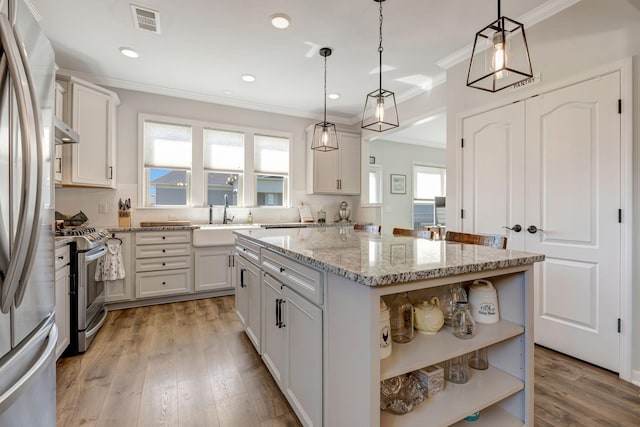 1235 Del Webb Blvd, Spring Hill, TN 37174 - kitchen featuring a sink, a center island, stainless steel appliances, visible vents, and ornamental molding
