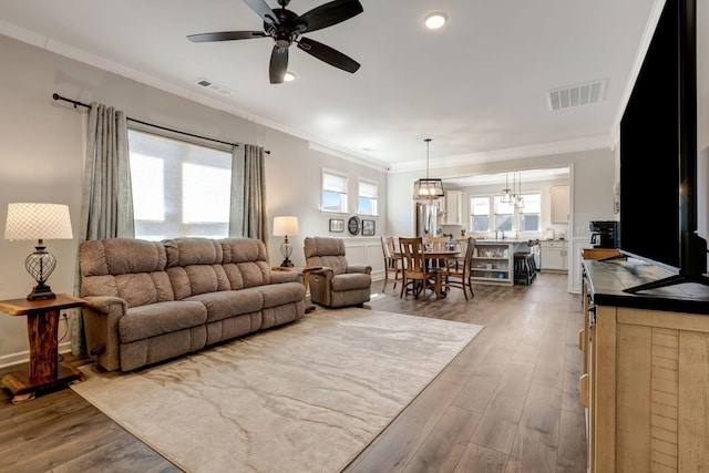 1235 Del Webb Blvd, Spring Hill, TN 37174 - living area with crown molding, visible vents, ceiling fan with notable chandelier, and light wood-style floors