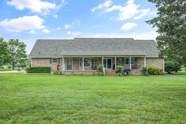 140 Keele Rd, Manchester, TN 37355 - view of front of home with covered porch, a front yard, a shingled roof, and brick siding