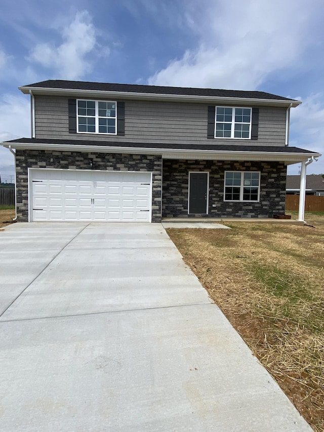 view of front facade featuring an attached garage, driveway, and stone siding