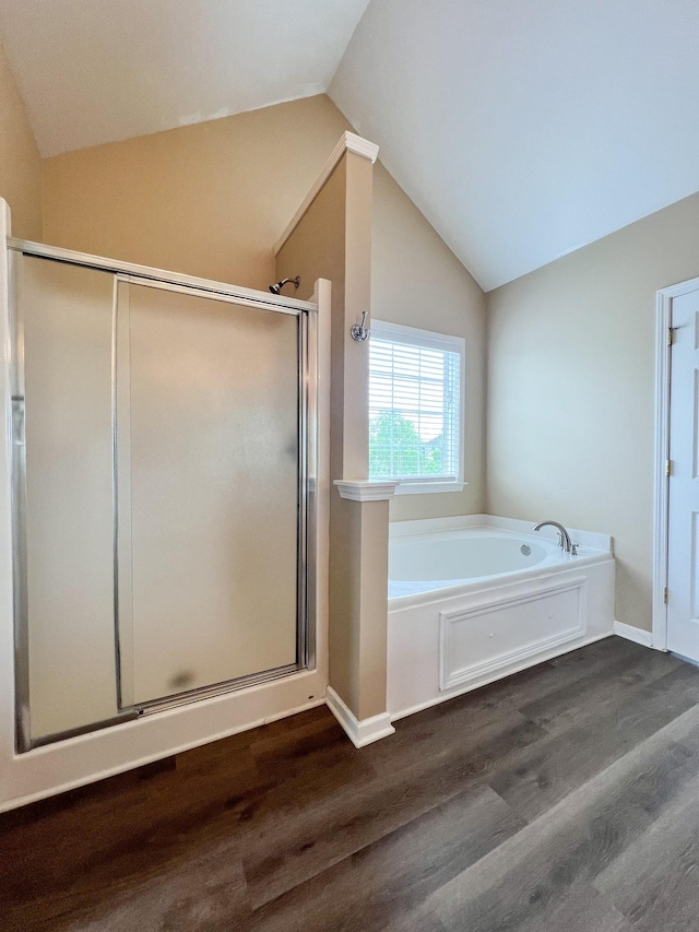 full bath featuring a bath, wood finished floors, and lofted ceiling