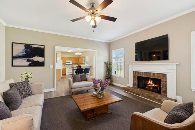 1030 Persimmon Dr, Spring Hill, TN 37174 - living area featuring ornamental molding, a lit fireplace, baseboards, a ceiling fan, and a chandelier