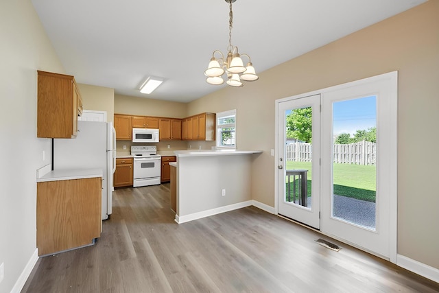 1030 Persimmon Dr, Spring Hill, TN 37174 - kitchen featuring white appliances, a chandelier, light countertops, wood finished floors, and a peninsula